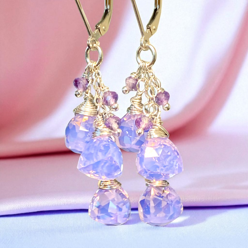 Purple beaded earrings with gold accents on a pink and purple gradient background