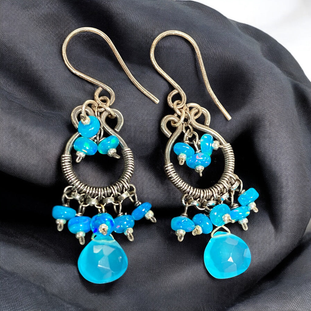 Pair of blue beaded earrings on a dark fabric background