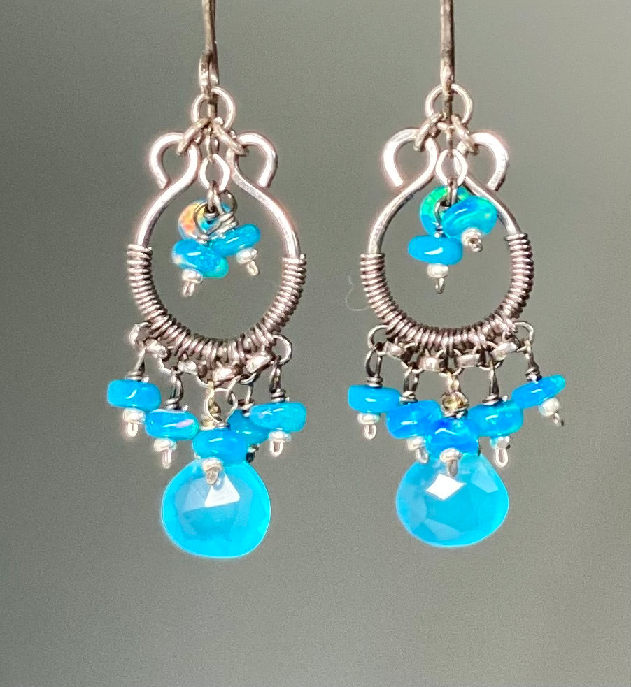Silver earrings with blue beads on a gray background