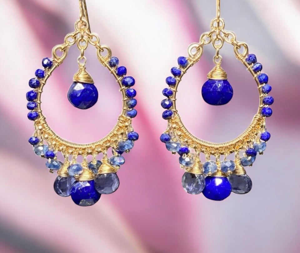 Gold hoop earrings with blue beads on a blurred background