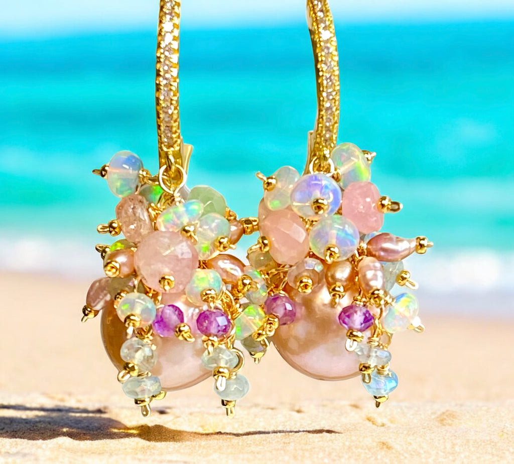 Gold earrings with colorful beads on a beach background