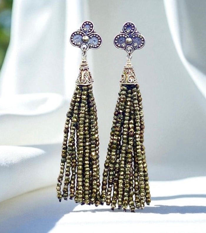 Pair of tassel earrings with floral tops on a white background