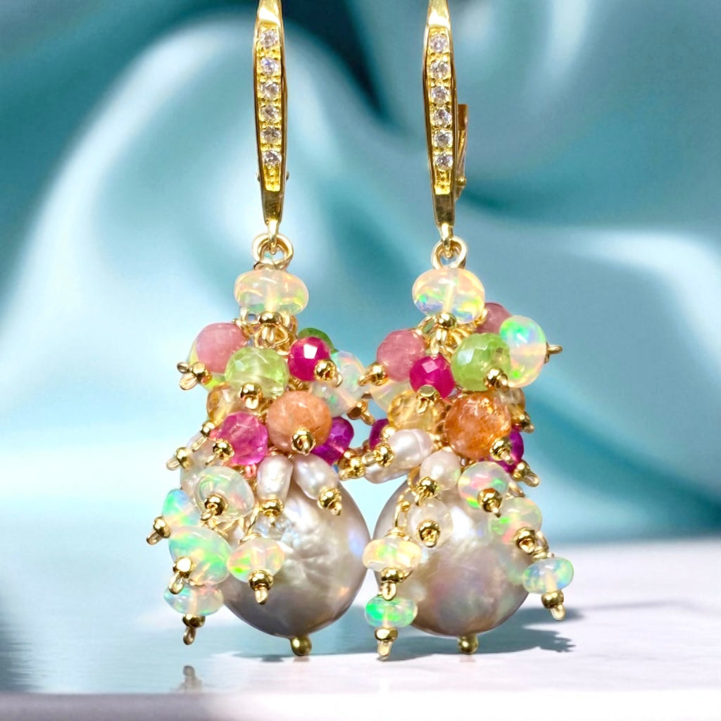 Elegant earrings with pearls, gemstones, and gold accents on a soft blue background