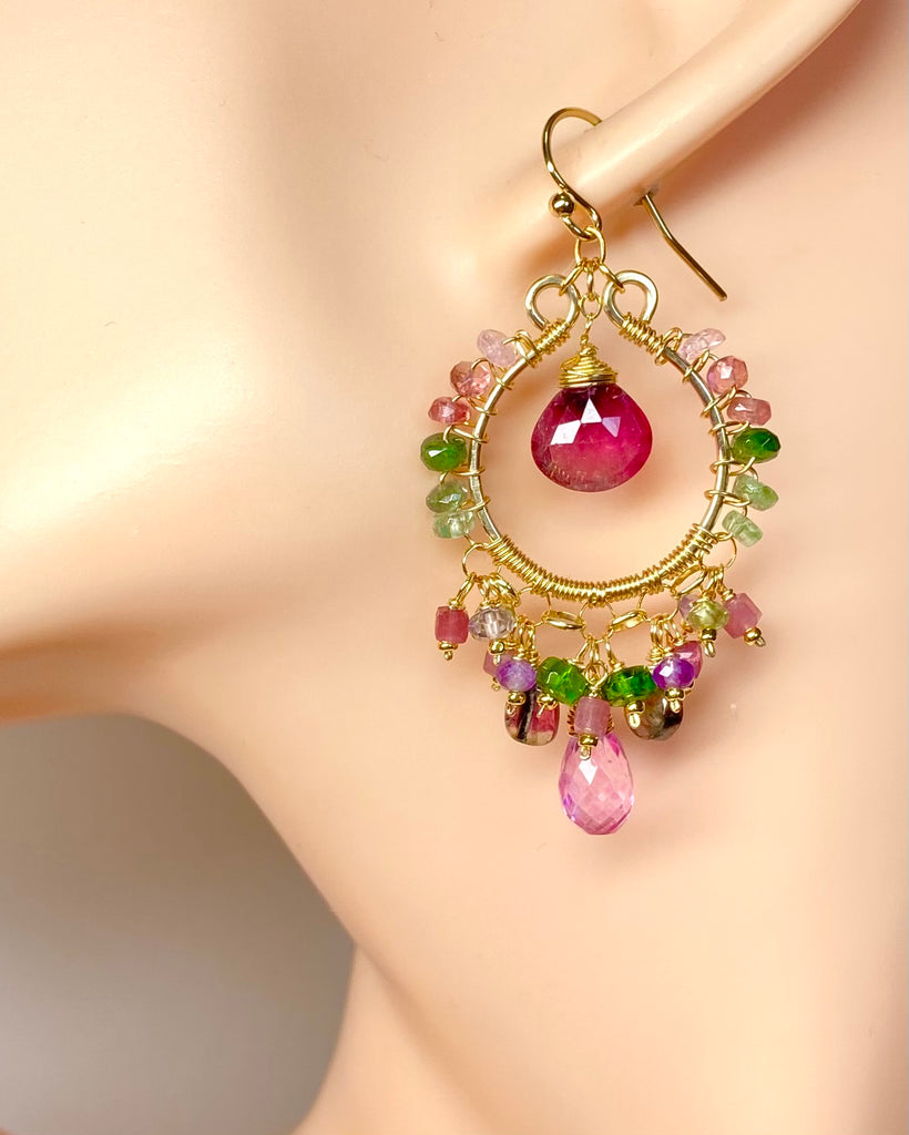 Multicolored gemstone earrings on a mannequin ear with a neutral background