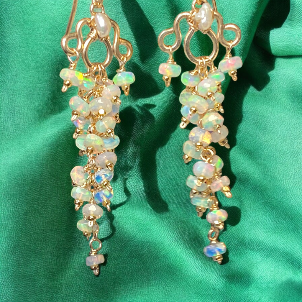 Opal earrings on a green fabric background