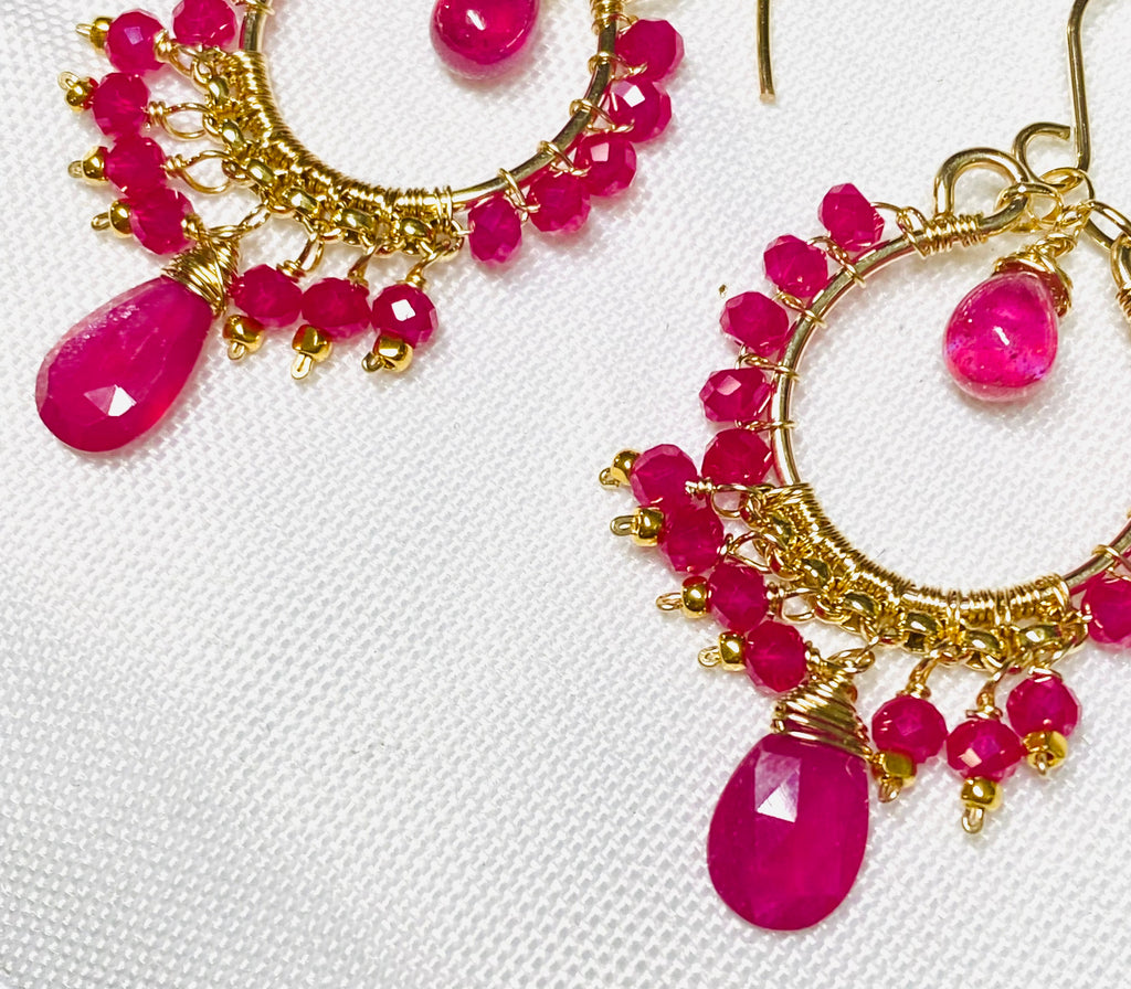 Red ruby pink sapphire gold chandelier hoop earrings closeup of pink sapphire briolette dangles on white fabric
