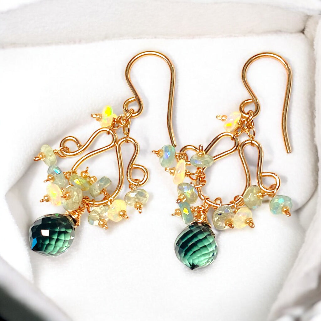 Opal and aquamarine rose gold chandelier earrings lying in white velvet lined jewelry box