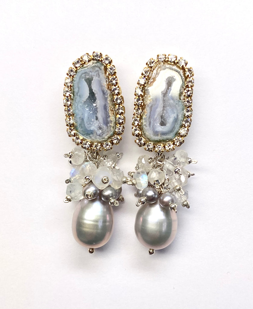 Elegant earrings with gemstones and pearls on a white background