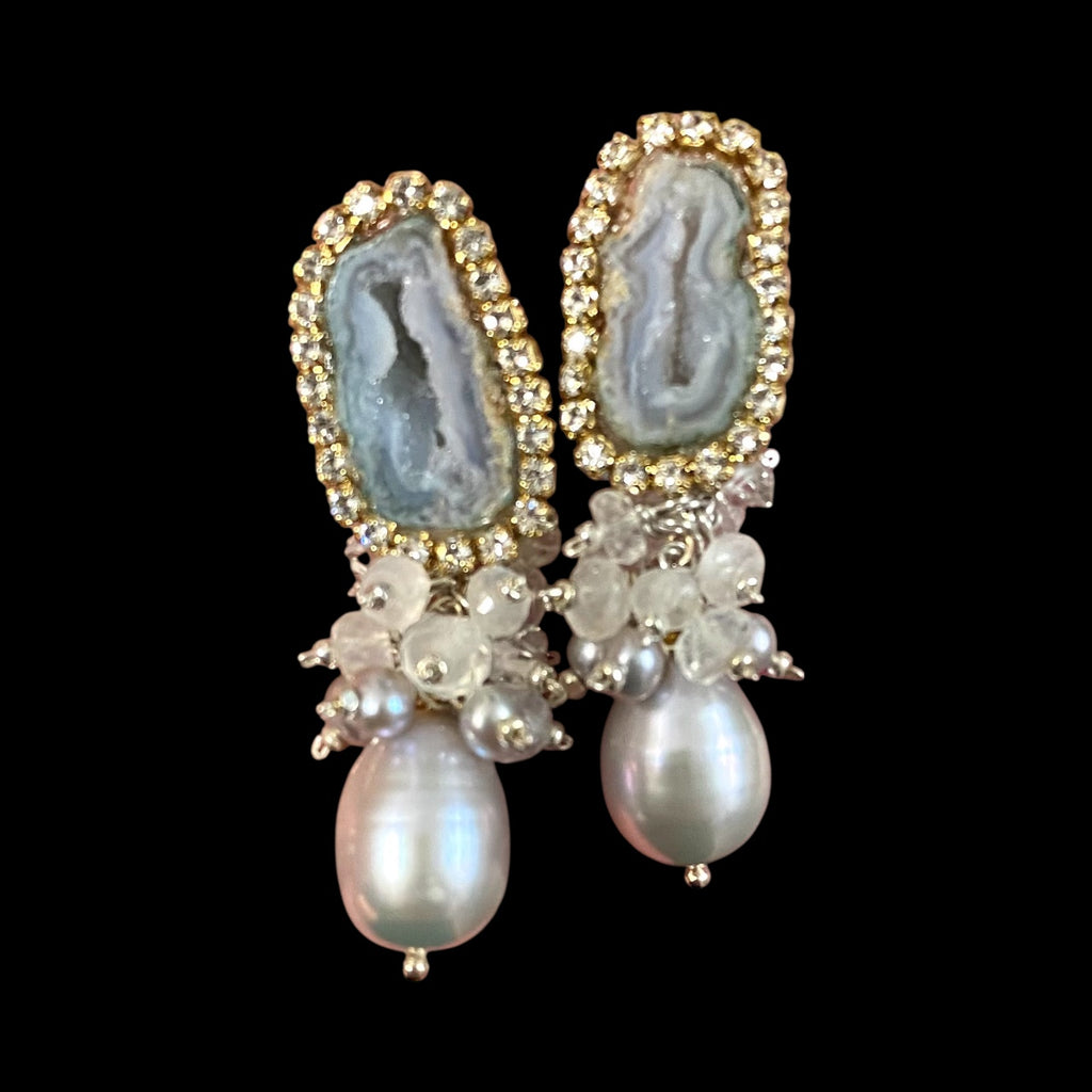 Earrings with gemstones and pearls on a black background