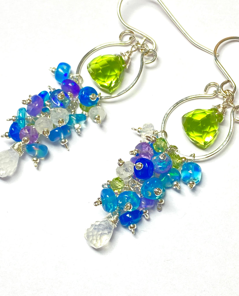 Colorful beaded earrings with green and blue stones on a white background
