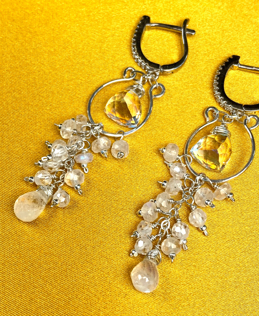 Angled view of sterling silver tassel earrings with rainbow quartz trillions, clustered moonstones, white zircon rondelles and moonstone teardrops.