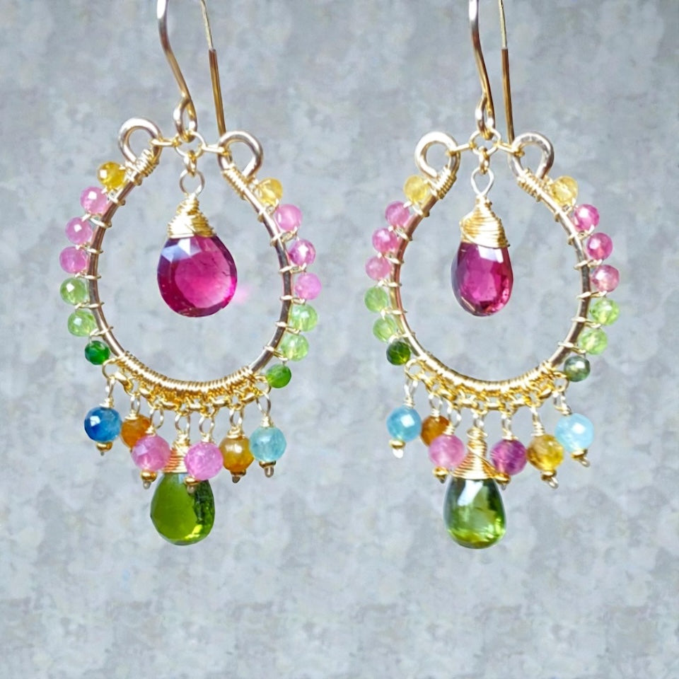 Multicolor tourmaline chandelier hoop earrings gold fill in front of grey textured wall