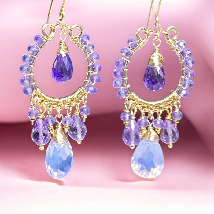  Pink lavender amethyst chandelier earrings with concave cut center stones dangling in front of draped pink fabric