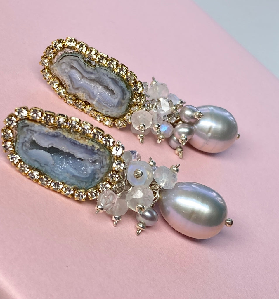 Earrings with geode druzy stones and pearls on a pink background