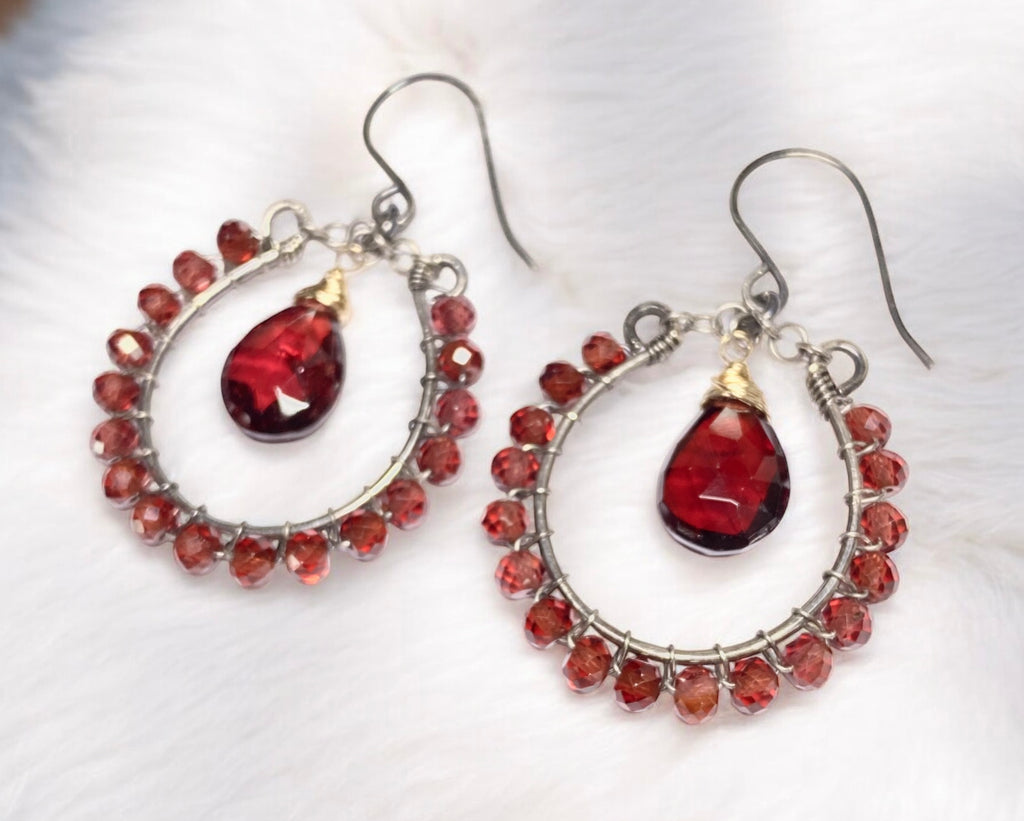 Red garnet hoop earrings mixed metals oxidized sterling silver and 14kt gold fill lying on white furry fabric