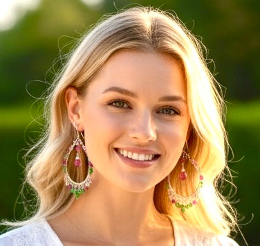 Pink sapphire tsavorite garnet sterling silver chandelier hoop earrings on model by pool showing resort wear styling and how earrings drape when worn