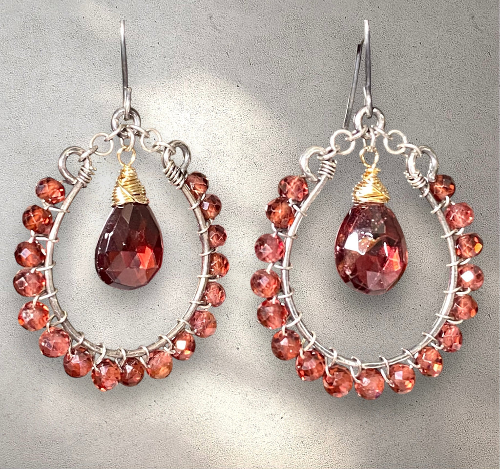 Red garnet hoop earrings mixed metals oxidized sterling silver and 14kt gold fill against light grey background