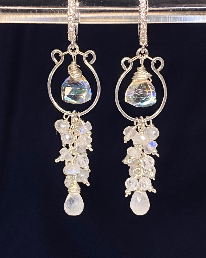 Pair of sterling silver chandelier earrings with white gemstones on a clear stand against a black background showing pave lever back earring option.