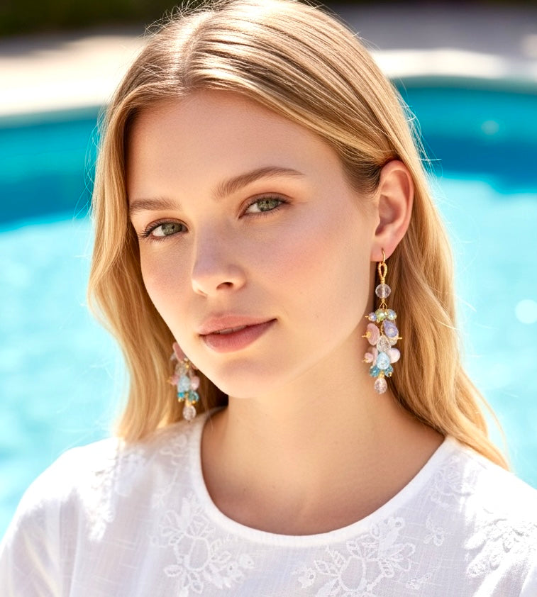  Earrings dangling on model in front of a pool.