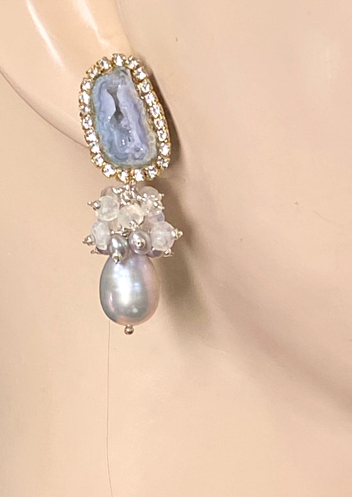Earring with gemstone and pearl design on a mannequin ear