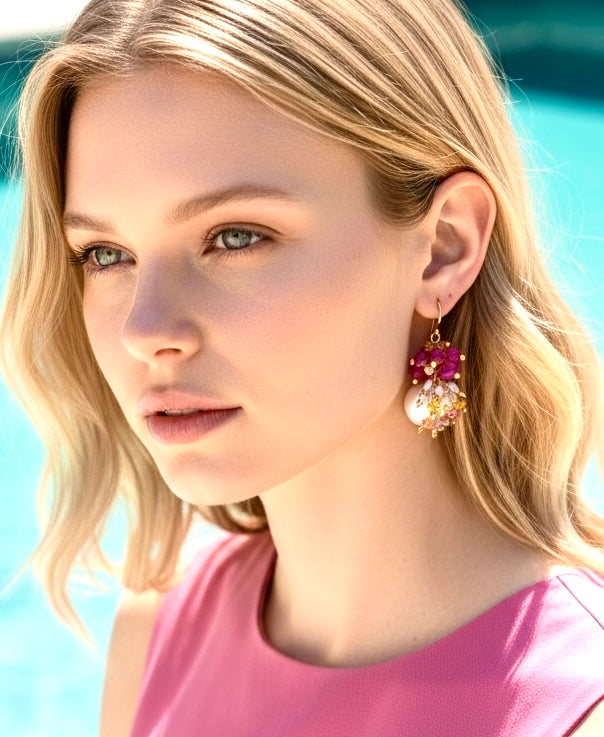 Blonde model in pink dress wearing pearl and pink sapphire cluster earrings gold - close-up headshot showing earring detail