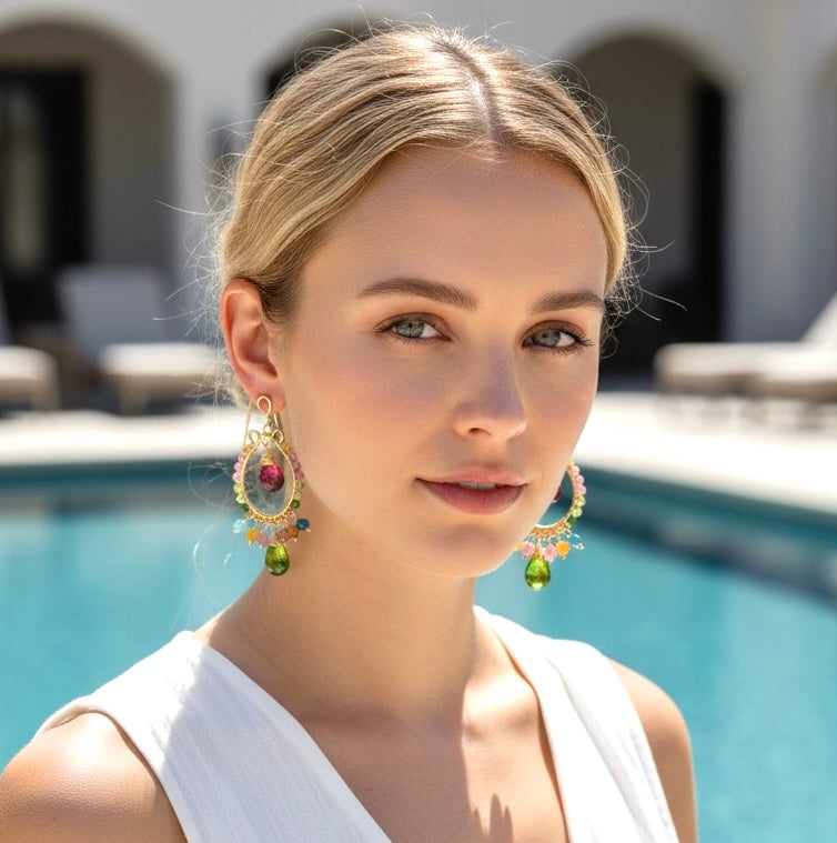 Multicolor tourmaline gold chandelier hoop earrings on blonde model in white dress at resort pool