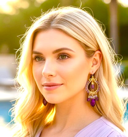 Blonde model wearing tanzanite iolite amethyst violet quartz gold filled chandelier earrings in front of pool showing twilight purple blue gemstones