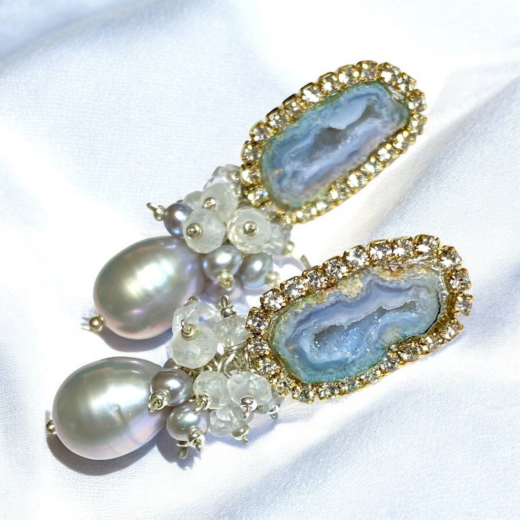 Earrings with grey tabasco geodes and pearl stones on a white background