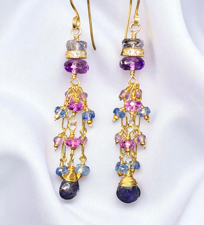 Iolite amethyst long dangle gold filled earrings daling infront of white draped fabric