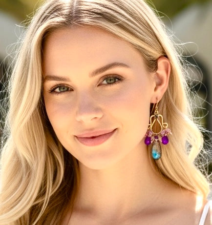 Purple labradorite amethyst rose gold chandelier earrings on blonde model at beach resort
