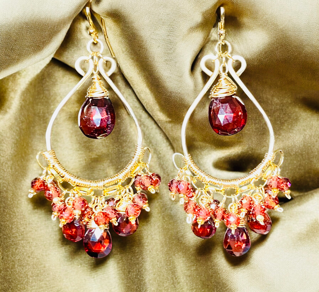 Red garnet chandelier earrings 14kt gold fill dangling over draped gold velvet fabric