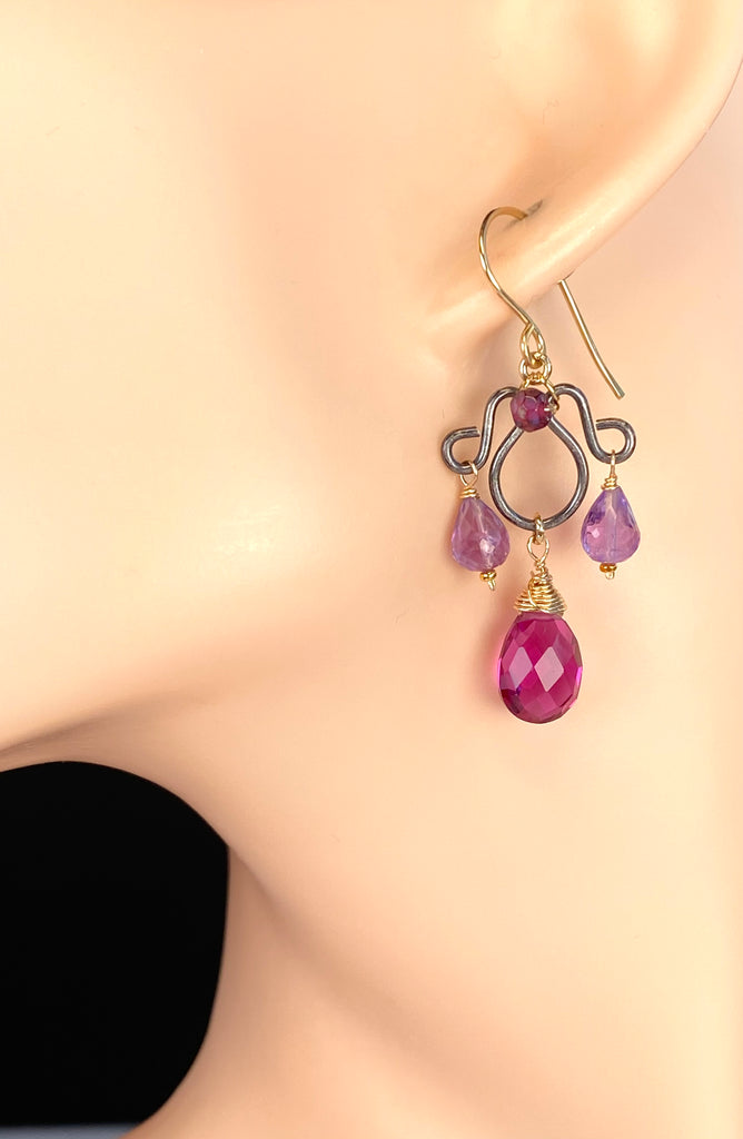 Violet rhodolite garnet and lavender amethyst chandelier earring on a mannequin ear, showing its dangling shape and gold-filled French hook.