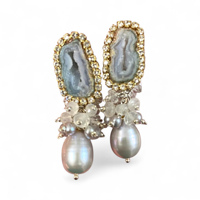 Elegant earrings with gemstones and pearls on a white background