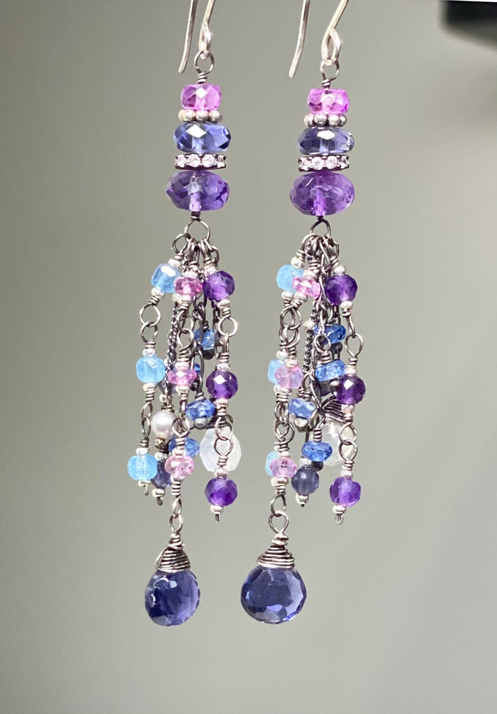 pair of blue purple gemstone wire wrapped long earrings on a grey background