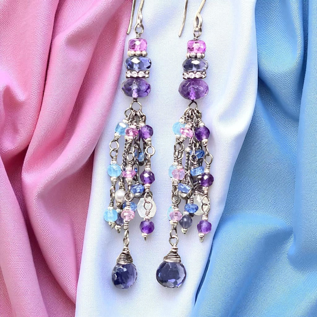 Beaded earrings with purple and pink beads on a fabric background