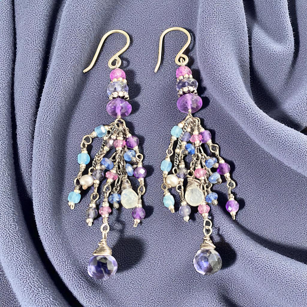 Multicolored beaded earrings on a soft purple fabric background