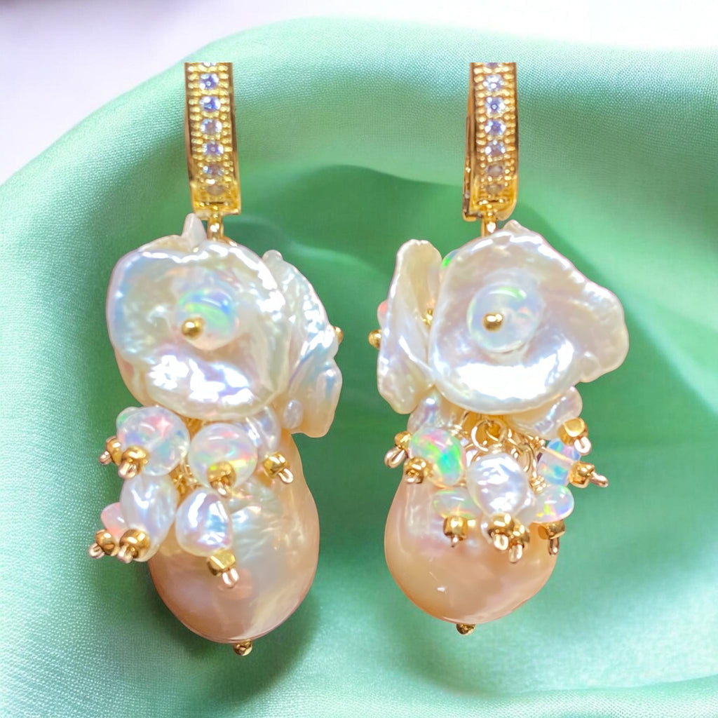 Pair of pearl earrings with gold accents on a light green background