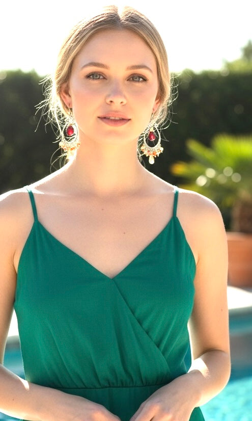 Red garnet citrine mixed metal hoop earrings on model wearing green dress in pool setting