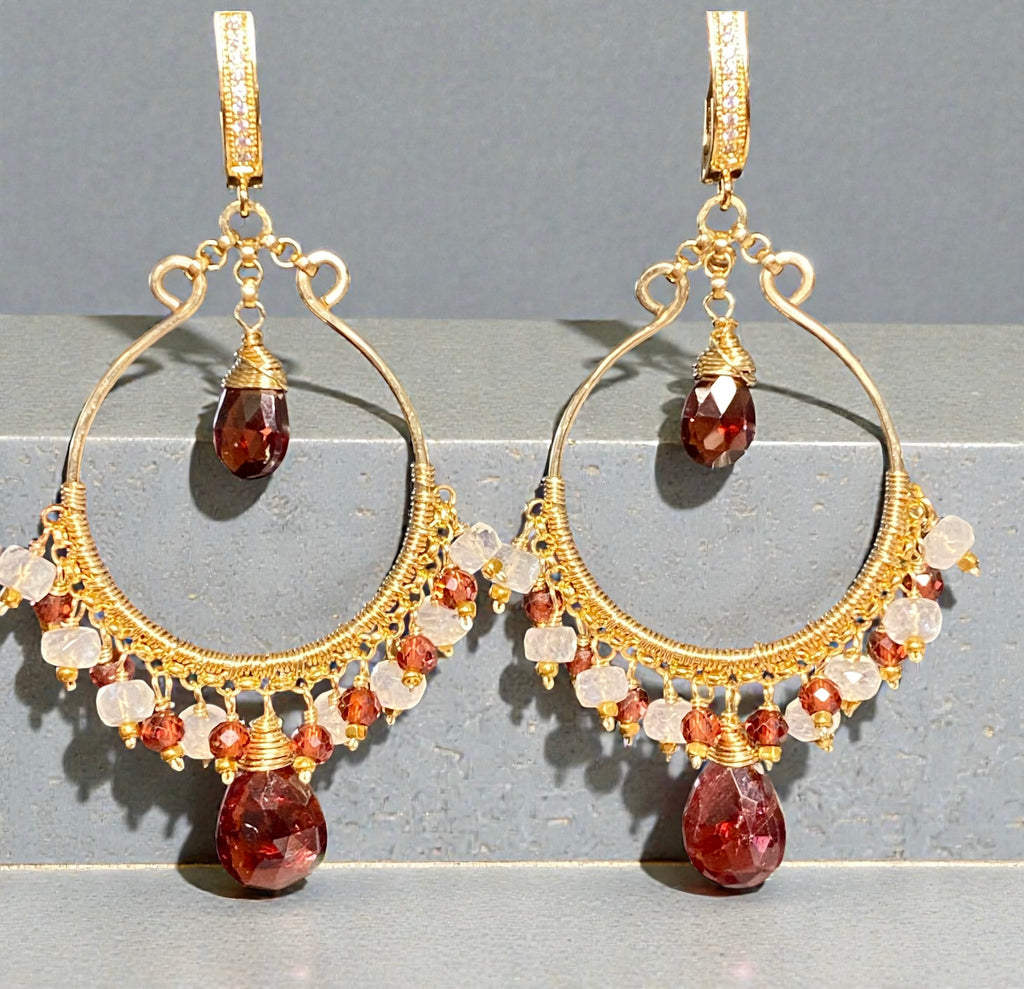 Red garnet and rainbow moonstone gold filled chandelier hoop earrings against grey block background