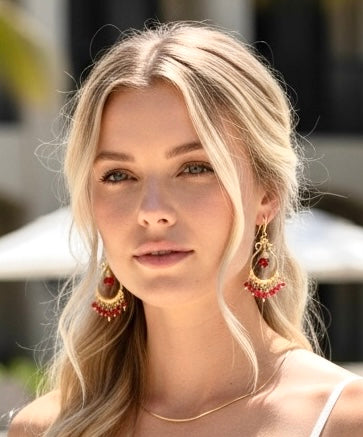 Red garnet chandelier hoop earrings 14kt gold fill worn by blonde model headshot in pool resort setting