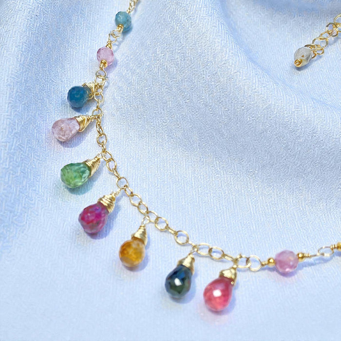 Necklace with colorful gemstones on a light blue fabric background